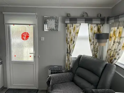 a living room with a chair and a window at Cairnryan Heights home from home in Cairnryan
