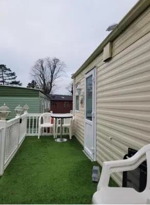 a patio with a table and chairs next to a house at Cairnryan Heights home from home in Cairnryan