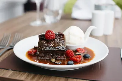 a plate of chocolate dessert with ice cream and berries at The Empress Hotel in Douglas