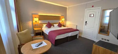 a hotel room with a bed and a table at The Empress Hotel in Douglas