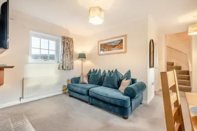 a blue couch in a living room with a window at 3 Bed in Workington oc-92628 in Dean