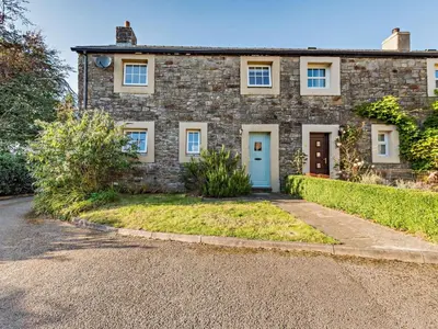 a brick house with a blue door and a driveway at 3 Bed in Workington oc-92628 in Dean