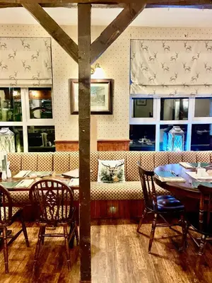 a dining room with tables and chairs and windows at Room with Newly Renovated Private Bathroom above Village Pub Stag Inn Crosby Maryport in Maryport