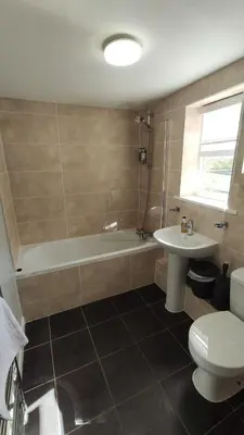 a bathroom with a tub and a toilet and a sink at The Boot Inn in Boot