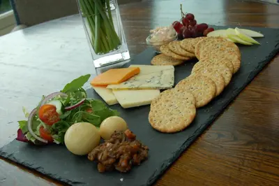 a plate of food with cheese and vegetables on a table at The Boot Inn in Boot