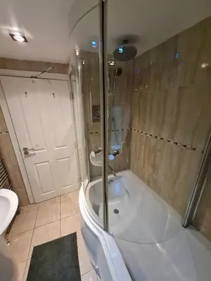 a bathroom with a shower and a tub and a sink at Douglas Head Road in Douglas
