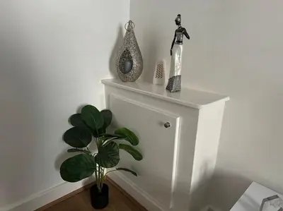 a white shelf with a plant and a bottle on it at Lonsdale Terrace - 3 Bedrooms - Sleeps 6 in Workington