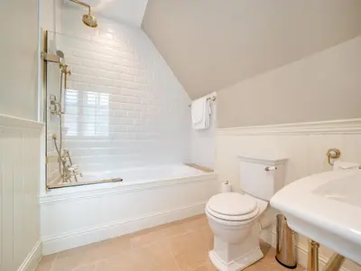 a white bathroom with a toilet and a bath tub at Lundin Links - Ukc6916 in Turnberry