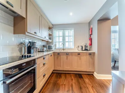 a kitchen with wooden cabinets and a wooden floor at Royal Aberdeen - Ukc6917 in Turnberry