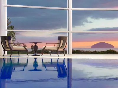 two chairs and a table next to a swimming pool at Royal Dornoch - Ukc6918 in Turnberry