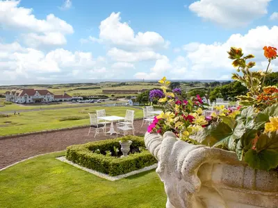 a garden with tables and chairs and flowers on a hill at Royal Dornoch - Ukc6918 in Turnberry