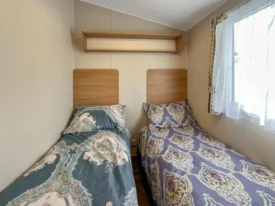two beds in a small room with a window at Peppy in Newton Stewart