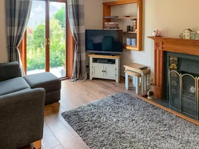 a living room with a tv and a fireplace at The Cottage in Whiting Bay