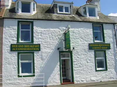 a white building with signs on the side of it at The Merchants House in Cairnryan
