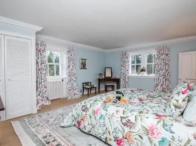 a bedroom with a bed with a floral bedspread at Country Home on Private Estate in Minishant