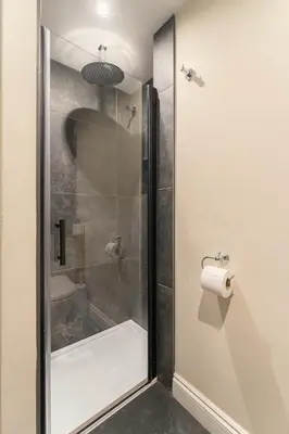 a shower stall in a bathroom with a toilet paper roll at Derwentwater View in Portinscale