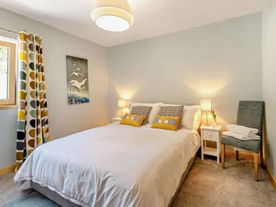 a bedroom with a large white bed and a chair at 4 Bed in Kippford 95234 in Kippford