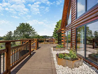 a wooden walkway next to a house with windows at 4 Bed in Kippford 95234 in Kippford