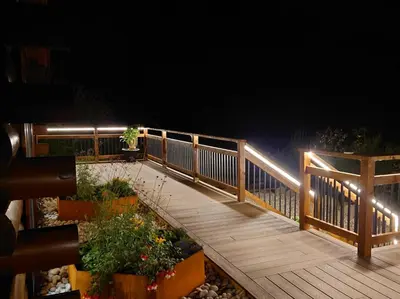 a wooden deck with a fence and lights on it at 4 Bed in Kippford 95234 in Kippford