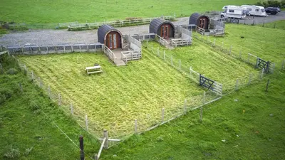a group of buildings in a field with grass at Unit 2 - Carrock View Camping Pod in Carlisle
