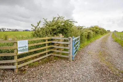 a fence on the side of a dirt road at Unit 4 - Skiddaw View Camping Pod in Carlisle
