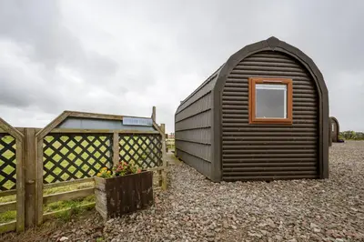 a small black shed next to a wooden fence at Unit 4 - Skiddaw View Camping Pod in Carlisle