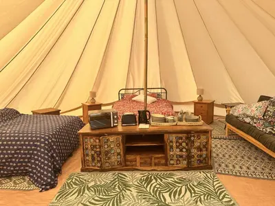 a room with a bed and a table in a tent at Unit 1 - Dolly Daydream Bell Tent in Carlisle