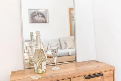 a table with two wine glasses and a mirror at Luxury townhouse in Workington in Workington