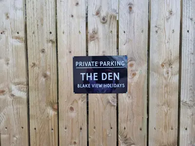 a sign on a wooden fence that reads private parking the den at The Den by Blake View Holidays a peaceful boutique retreat 3 miles from Ennerdale- standard twin or super-king bed available in Rowrah