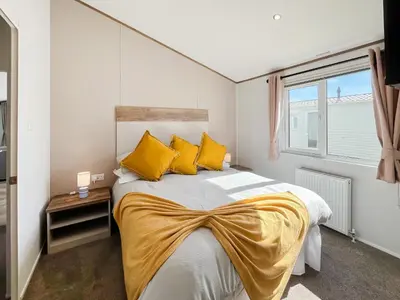 a bedroom with a large bed with yellow pillows at Bud's Bay in Mainsriddle