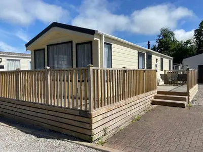 a small house with a wooden fence at Rhodes Retreat, Lake District in Brigham