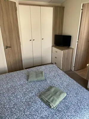 a bedroom with a bed with two towels on it at Rhodes Retreat, Lake District in Brigham