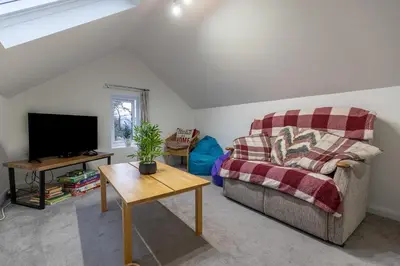 a living room with a couch and a tv at SHELTER STONE - Cottage in the heart of the Lakes in Keswick