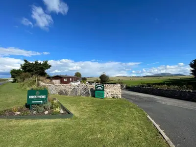 a sign for a house on the side of a road at Lake District Stunning Lodge in Plumbland