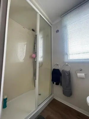 a bathroom with a shower with a glass door at Lake District Stunning Lodge in Plumbland