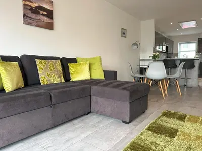a living room with a brown couch and a table at Chapel Terrace - 2 Bedrooms - Sleeps 4 in Cleator Moor