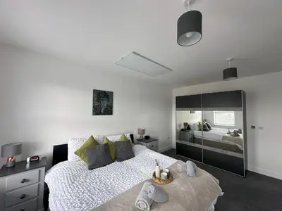 a bedroom with a large bed and a large mirror at Chapel Terrace - 2 Bedrooms - Sleeps 4 in Cleator Moor