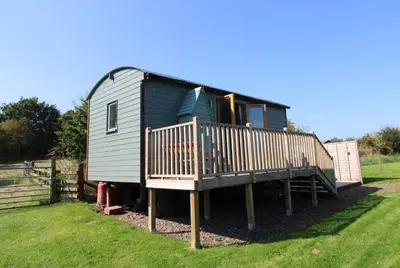 a tiny house with a porch and a deck at Puddleduck Hut Armathwaite with hot tub and dog agility course, perfect for a romantic break in Armathwaite