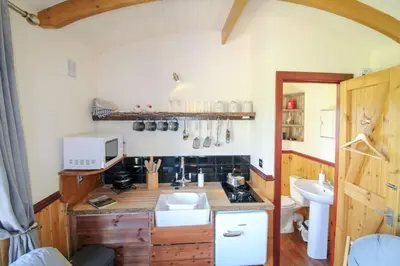 a small kitchen with a sink and a microwave at Puddleduck Hut Armathwaite with hot tub and dog agility course, perfect for a romantic break in Armathwaite