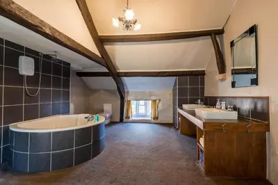 a large bathroom with a tub and two sinks at Gosforth Hall Inn in Gosforth