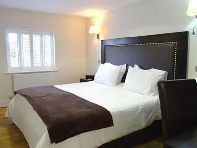 a bedroom with a large bed with white sheets and pillows at Gosforth Hall Inn in Gosforth