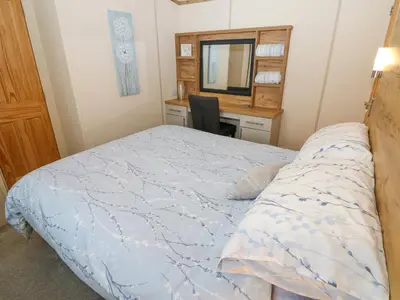 a bedroom with a bed and a desk with a mirror at Plot 41 in Carlisle