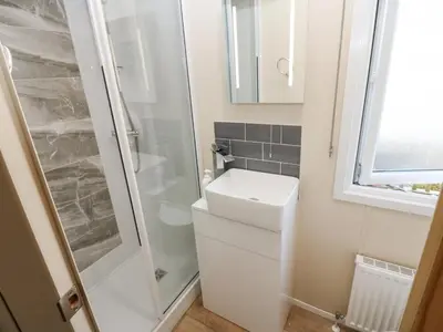 a bathroom with a shower and a toilet and a sink at Plot 41 in Carlisle