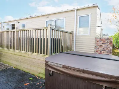 a house with a wooden fence and a trampoline at Plot 41 in Carlisle