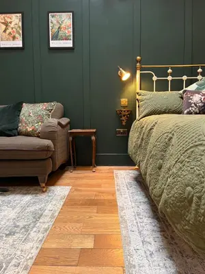 a bedroom with a bed and a couch and a chair at Dinmont Cottage in Dalston