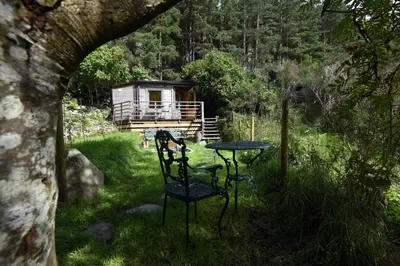 a table and chair in a yard with a cabin at Helvellyn - The Hut - Twin or Double in Glenridding