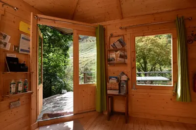 a wooden cabin with a window and a porch at Helvellyn - The Hut - Twin or Double in Glenridding