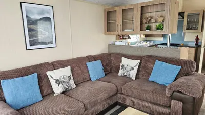 a brown couch in a living room with pillows on it at The Lake District Caravan in Lamplugh