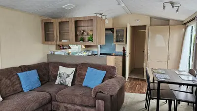 a living room with a brown couch and a table at The Lake District Caravan in Lamplugh