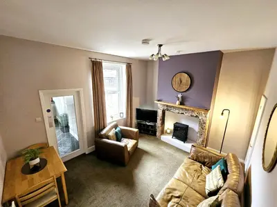 a living room with a couch and a fireplace at Ashley House, Carlisle in Carlisle